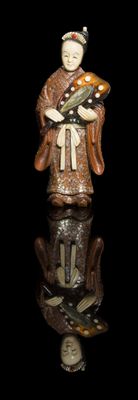 chinese figurine of a man holding a fish on a black surface
