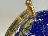 a close up of a blue and gold globe on a table