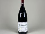 une bouteille de vin rouge posée sur une table blanche