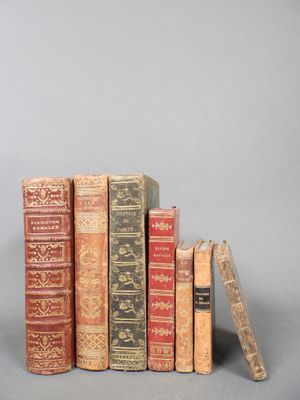plusieurs vieux livres empilés les uns sur les autres sur une surface grise