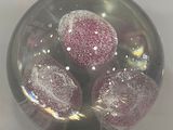 a glass ball with three balls in it on a table