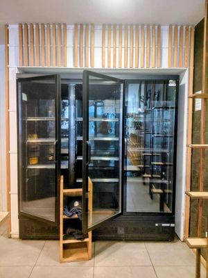 une porte vitrée qui donne sur une pièce remplie d'étagères, les unes après les autres