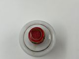 a white vase with a red lid on a white table