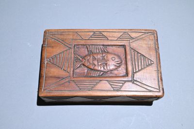 a wooden box with a fish on it on a table