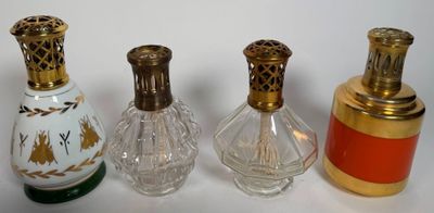 three small glass perfume bottles are lined up on a white surface