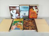 plusieurs livres posés sur une boîte en carton, elle-même posée sur une table