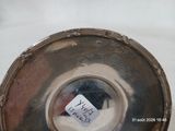une assiette en argent sur laquelle est collé un autocollant, posée sur une table