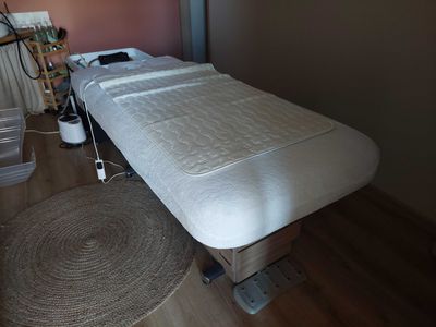 une table de massage recouverte d'un matelas, dans une pièce