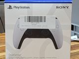 La boîte de la manette PlayStation est posée sur une table en bois.