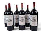 four bottles of red wine are lined up on a white surface