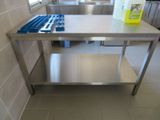 une table en acier inoxydable avec une plaque de cuisson bleue