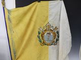 yellow and white flag with a coat of arms on top of it