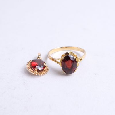 two rings with garnets on them on a white surface