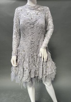 a mannequin wearing a gray dress with feathers on it