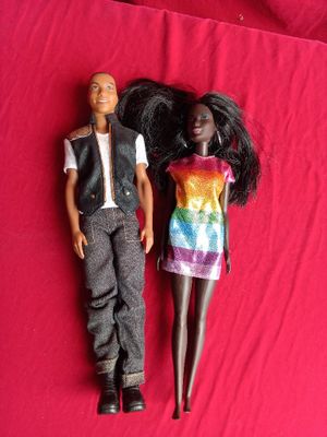 two dolls laying next to each other on a red surface