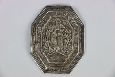a silver coin with a castle on it on a white surface
