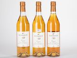 trois bouteilles de vin posées les unes à côté des autres sur une surface blanche