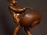 bronze statue of a boy with a basket on a wooden base