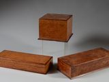 trois petites boîtes en bois posées les unes à côté des autres sur une table