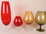 quatre vases en verre de couleurs différentes placés les uns à côté des autres
