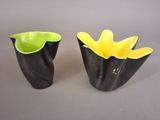two black and yellow vases sitting on a table