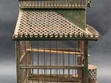a small bird cage with a bird inside of it