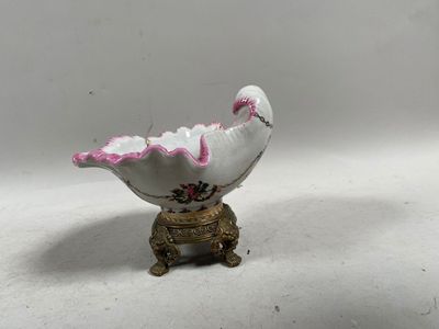 un oiseau blanc et rose perché sur un socle doré