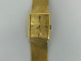 an image of a gold watch with a square face on a white surface