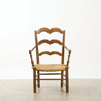 une photo d'une chaise en bois avec une assise tressée dans une pièce
