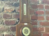 a clock hanging on a brick wall next to a brick wall