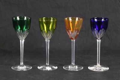 four different colored wine glasses are lined up in a row