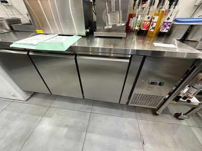 un comptoir en acier inoxydable sur lequel sont posées plusieurs bouteilles