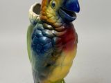 a figurine of a parrot sitting on a green base