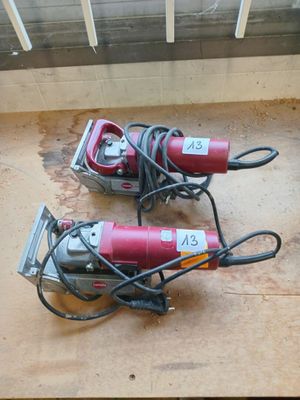 two electric tools sitting on the floor next to each other