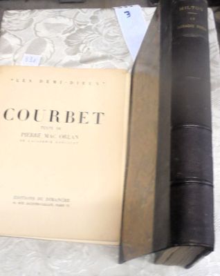 un livre posé sur une table, à côté de deux vieux livres