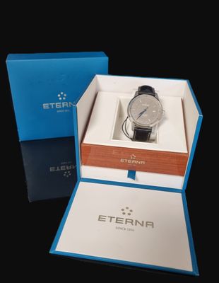 a box with a watch inside of it on a black surface