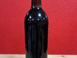 a bottle of red wine sitting on a wooden table