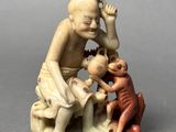 statue of a woman sitting on a rock with a baby and a monkey