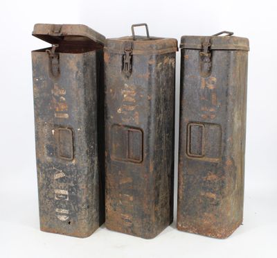 three old metal containers sitting next to each other on a white surface
