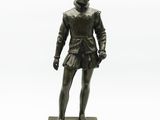 bronze statue of a boy in a skirt standing on a base