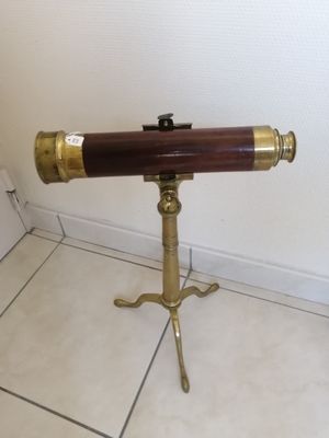 a telescope on a tripod stand on a tiled floor