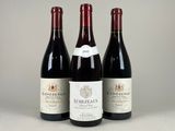 trois bouteilles de vin sont alignées sur une table