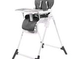 La chaise haute pour bébé est noire et blanche et est équipée d'un plateau.