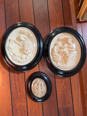 two framed pictures of a woman and a child on a wooden floor