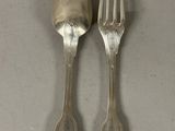 two spoons and a fork sitting on a table