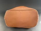 a tan leather toilet bag sitting on top of a table