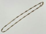 un collier en or avec une longue chaîne et un fermoir