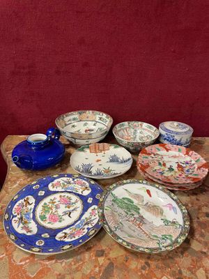many plates and bowls on a table with a red wall in the background