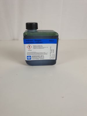 une bouteille contenant un liquide bleu posée sur une table blanche