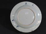 a white plate with blue designs on it on a black surface